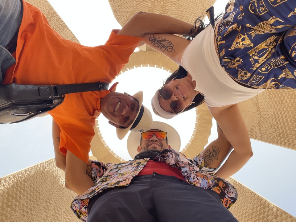 Trois amis se rassemblant sous une structure circulaire en pierre.