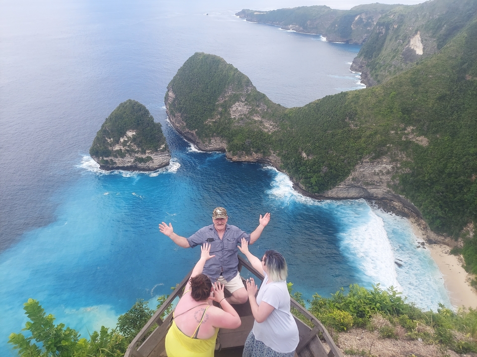Des gens qui font la fête sur une falaise surplombant l'océan.