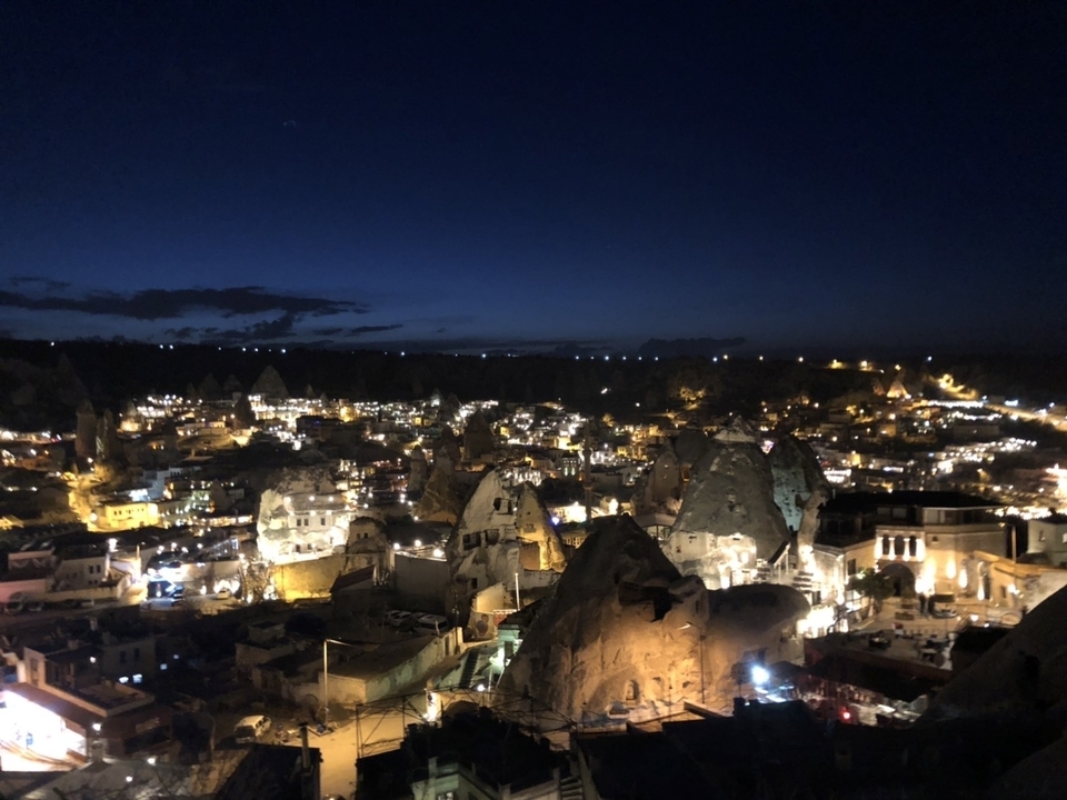Vue nocturne d'une ville avec des cheminées de fées et des lumières.