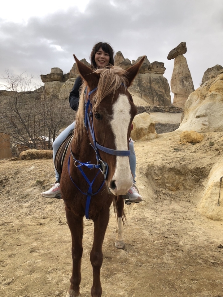 Personne à cheval dans un terrain rocheux.