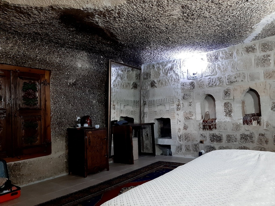 Chambre de grotte rustique avec des murs en pierre et des meubles en bois.