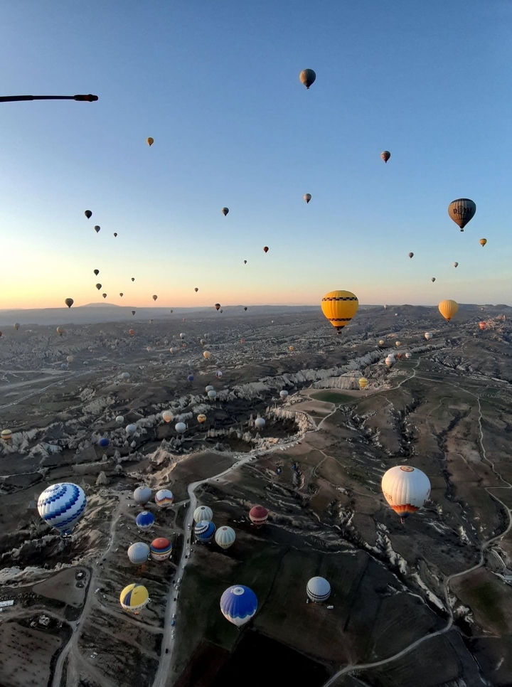 De nombreuses montgolfières au-dessus du paysage de la Cappadoce au lever du soleil.