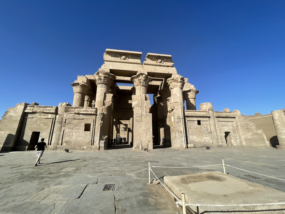 Grand temple égyptien antique avec des touristes en exploration.