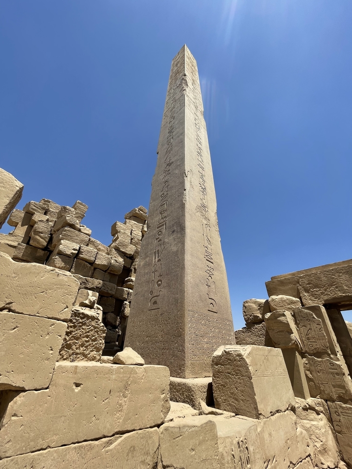 Grand obélisque avec hiéroglyphes contre un ciel bleu.