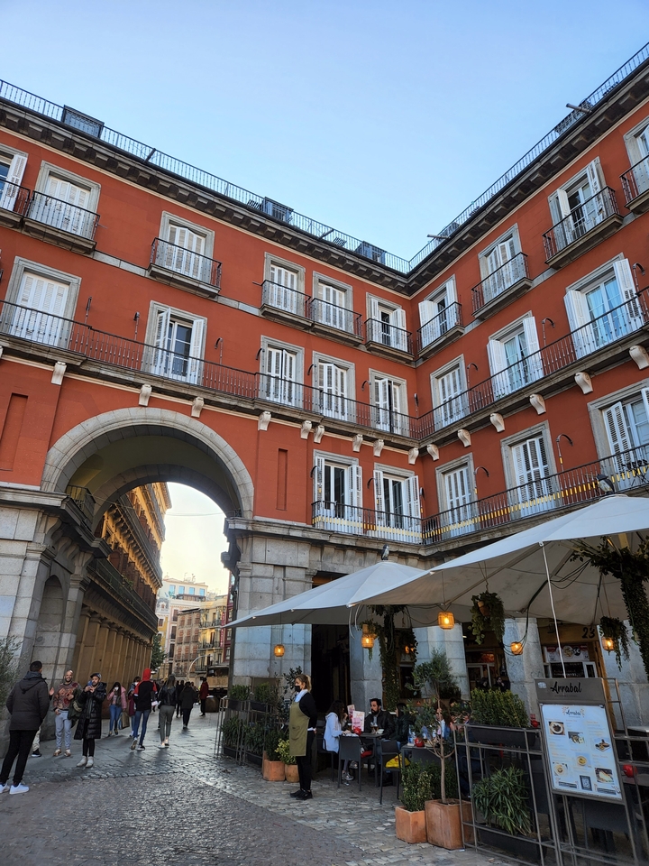 Red building facade with open plaza.