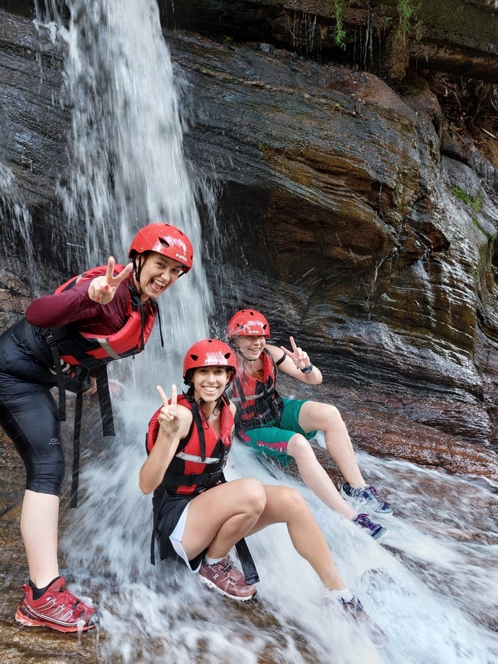 Trois personnes avec des casques sous une cascade