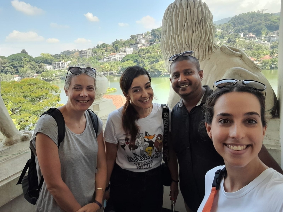 Groupe de personnes posant à un point de vue panoramique surplombant un lac