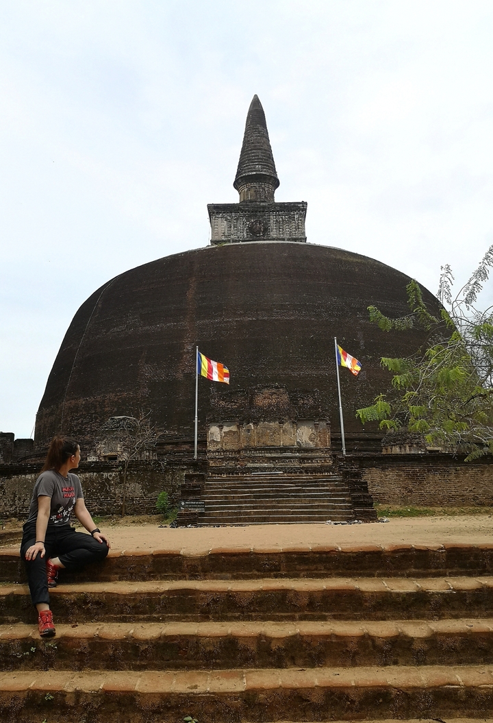 Personne observant d'anciens stupas avec des drapeaux