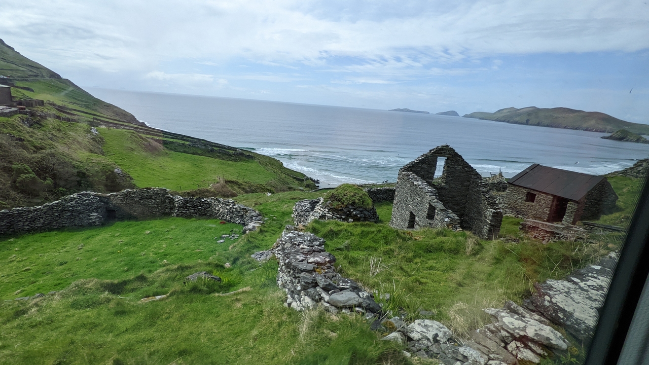 Paysage côtier pittoresque avec de vieux murs de pierre et des champs verts.