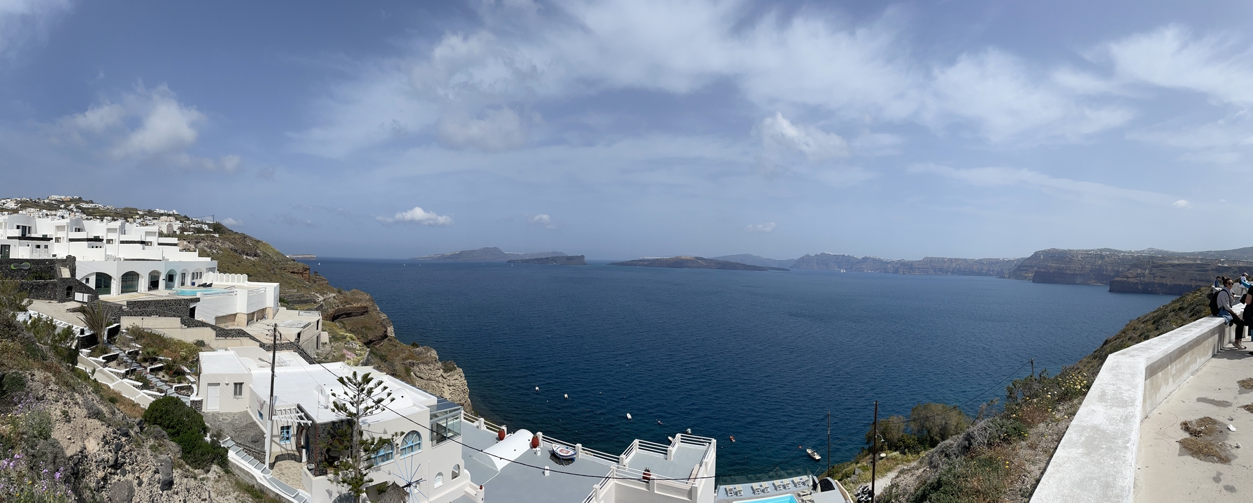 Vue panoramique d'un village à flanc de falaise avec la mer en arrière-plan.