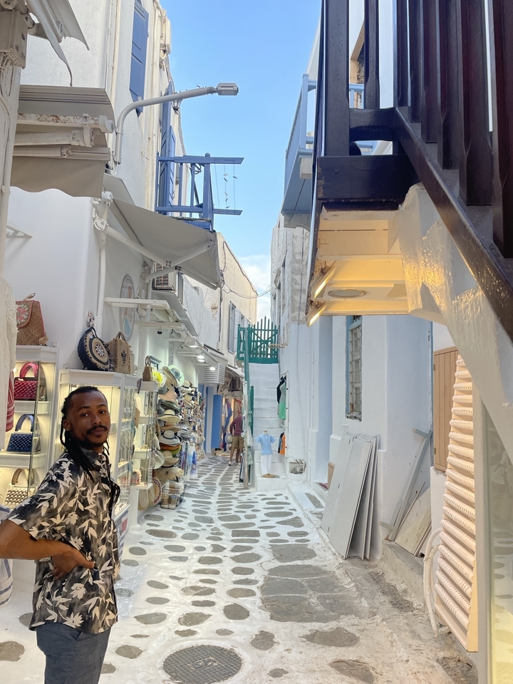 "Homme dans une rue étroite avec des magasins."