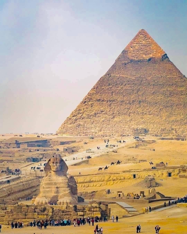 Complexe pyramidal de Gizeh, touristes et chameaux au premier plan.