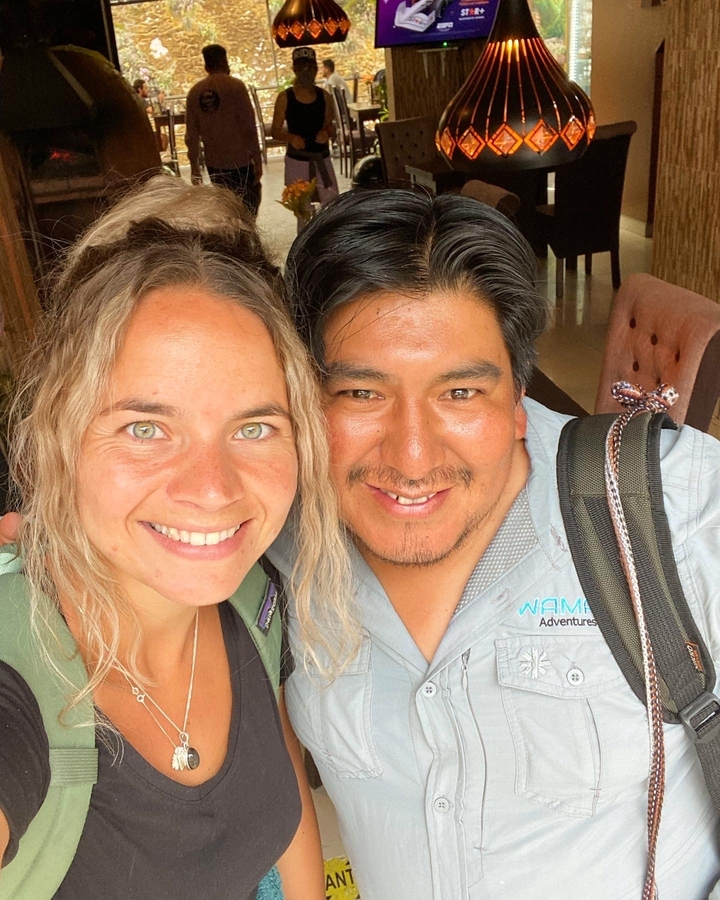 Un couple souriant posant près de la caméra avec des sacs à dos.