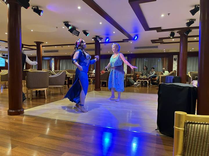 Deux femmes dansant sur une scène avec un public autour.