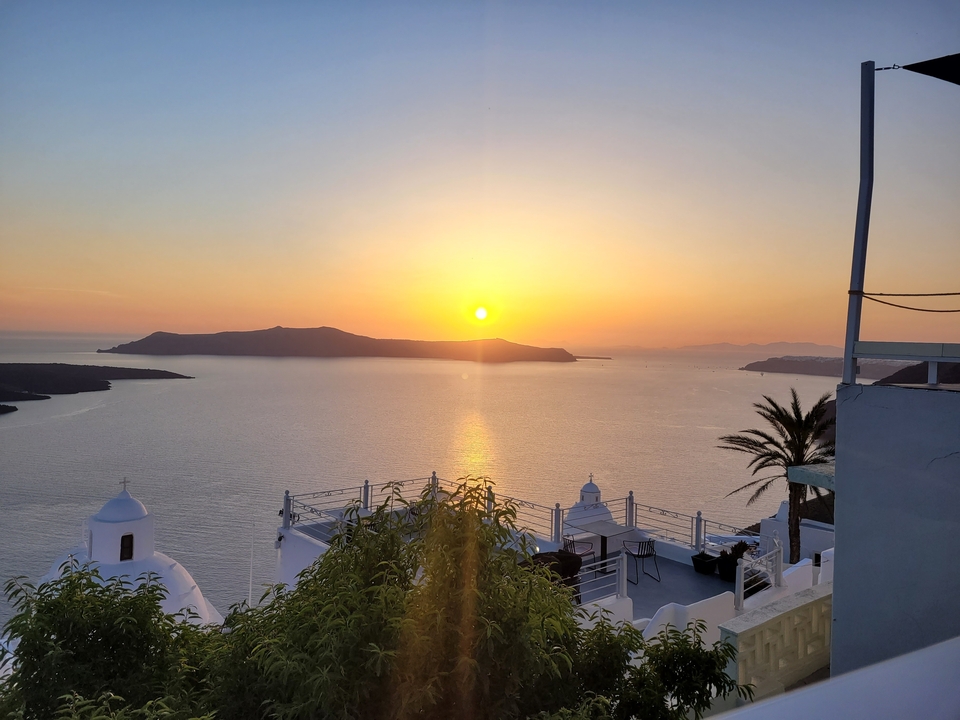 Vue du coucher de soleil sur l'océan depuis une villa blanche.