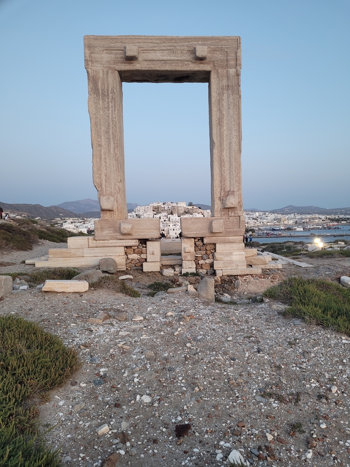 Ruines avec vue sur une ville côtière en arrière-plan.