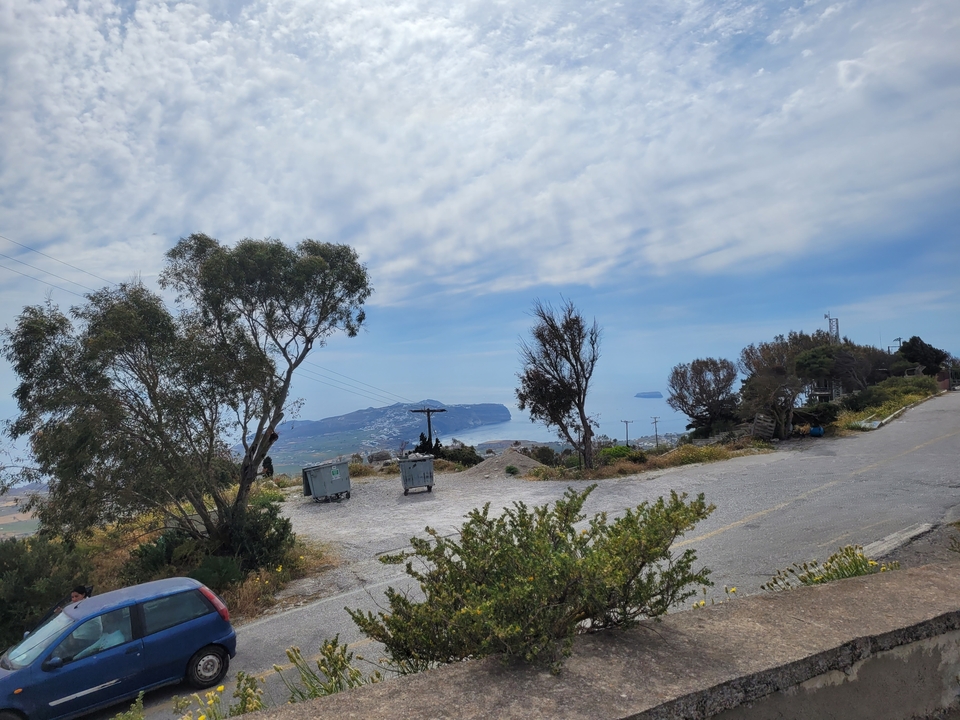 Vue panoramique depuis une colline avec des arbres et des îles au loin.