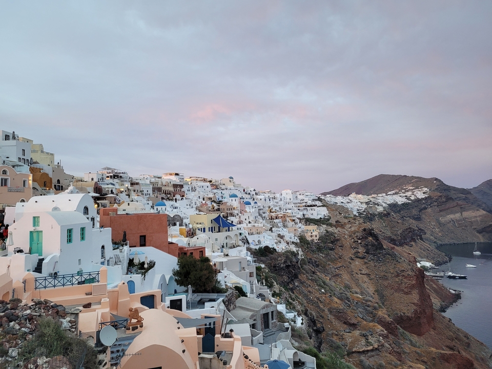 Village de Santorin avec des bâtiments blancs sur une falaise.