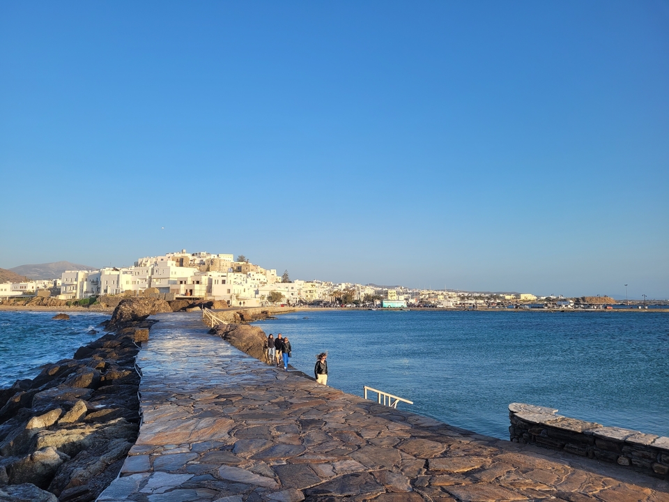 Vue d'une ville côtière avec des gens qui se promènent le long d'une jetée.