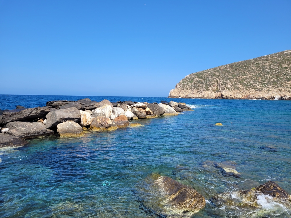 Rivage rocheux rencontrant une eau bleue claire.