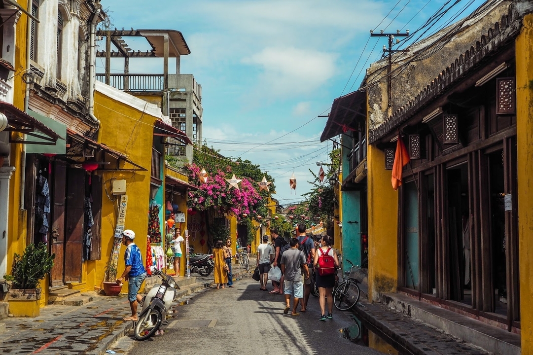 Une rue animée avec des boutiques et des gens dans une ville colorée.