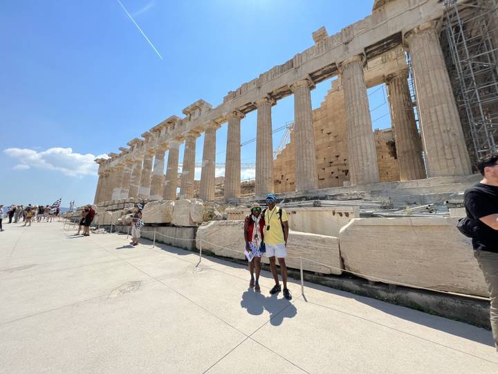 Deux personnes debout devant le Parthénon à Athènes.