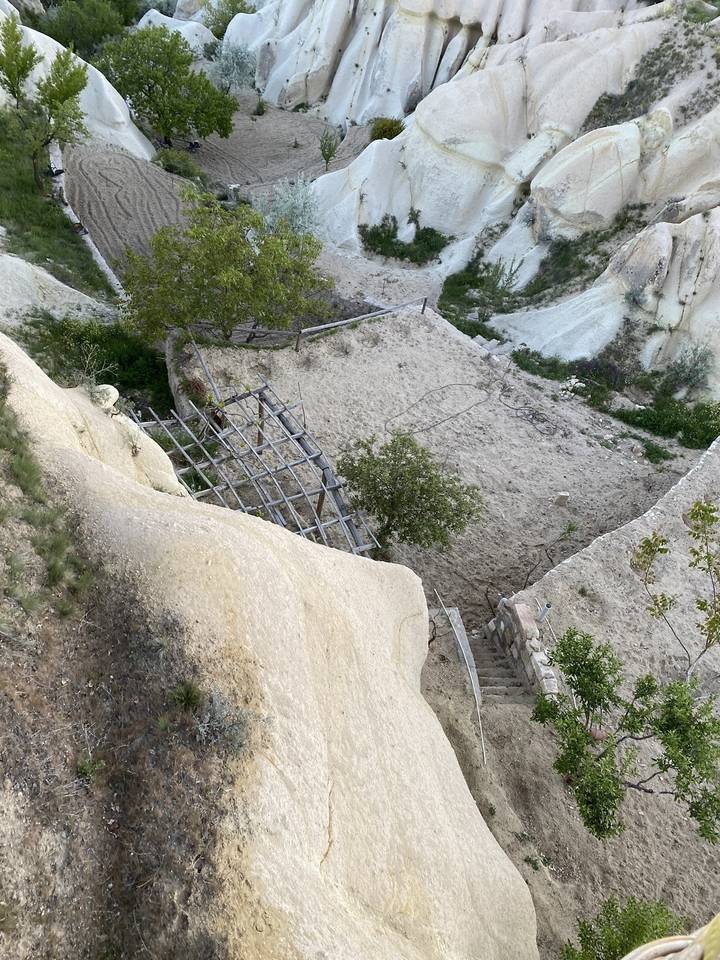 Une structure à flanc de colline avec une charpente de base dans un paysage.