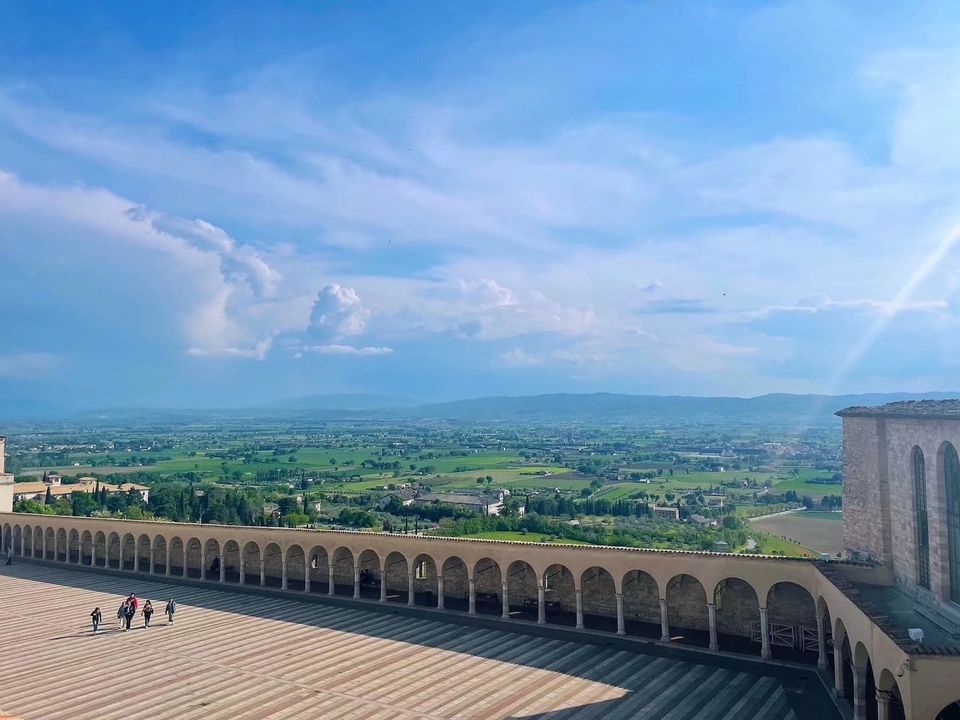Place spacieuse avec des passages voûtés donnant sur une vaste vallée.