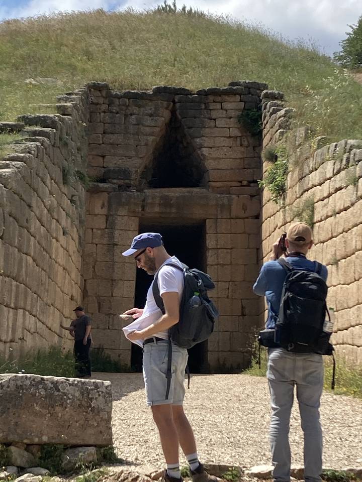 Des gens explorent une ancienne structure en pierre avec une entrée voûtée.