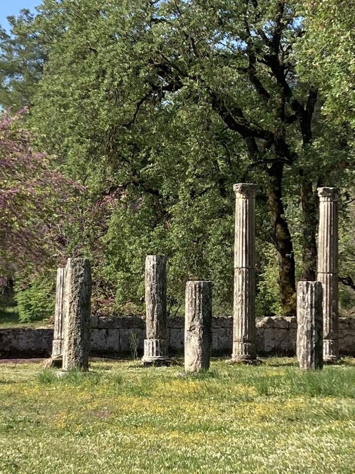 Anciens piliers de pierre dressés dans une zone herbeuse.