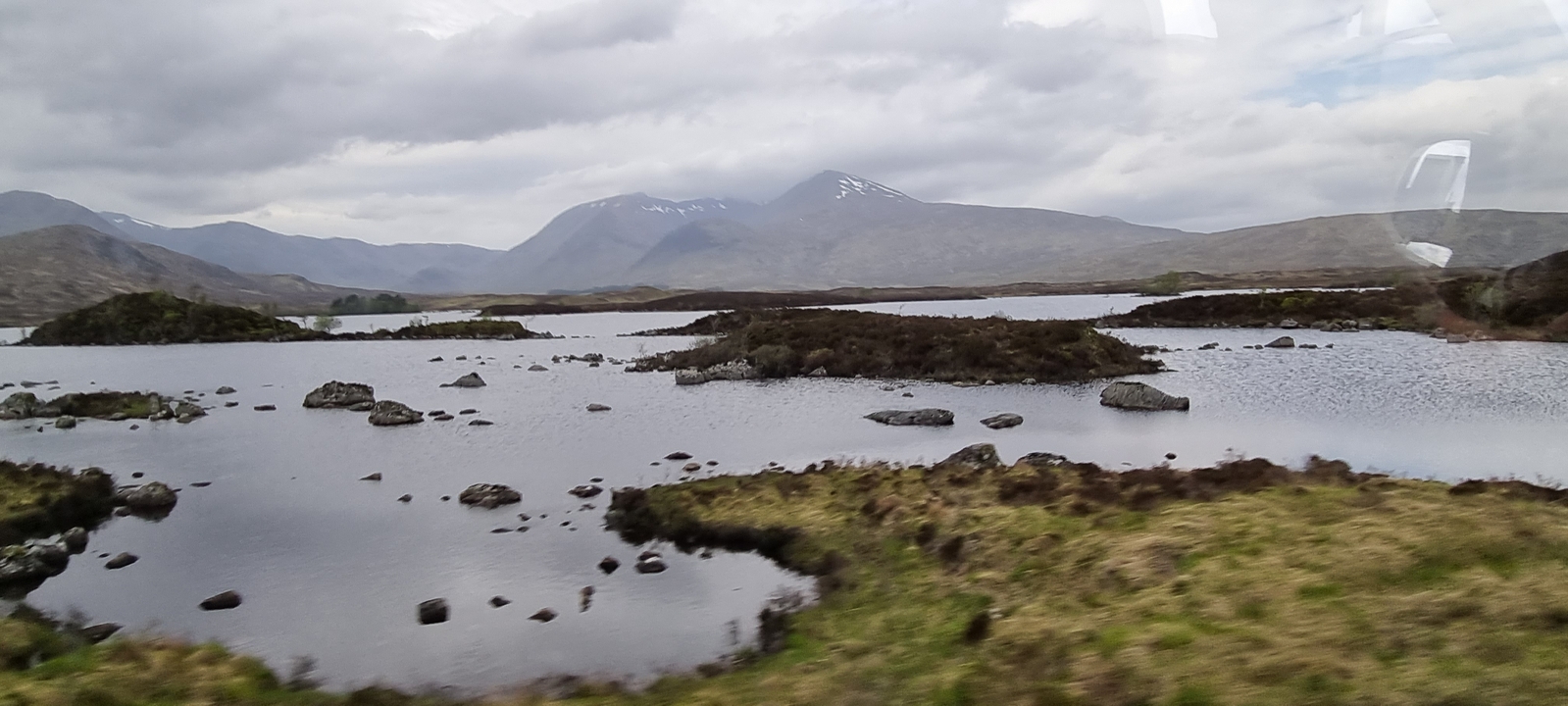 Étendue d'eau avec des îles éparses et des montagnes lointaines.
