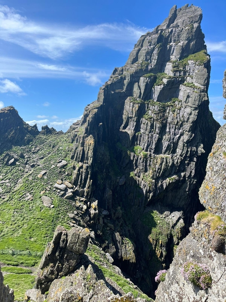 Formations rocheuses de falaises avec une végétation luxuriante sous un ciel bleu clair