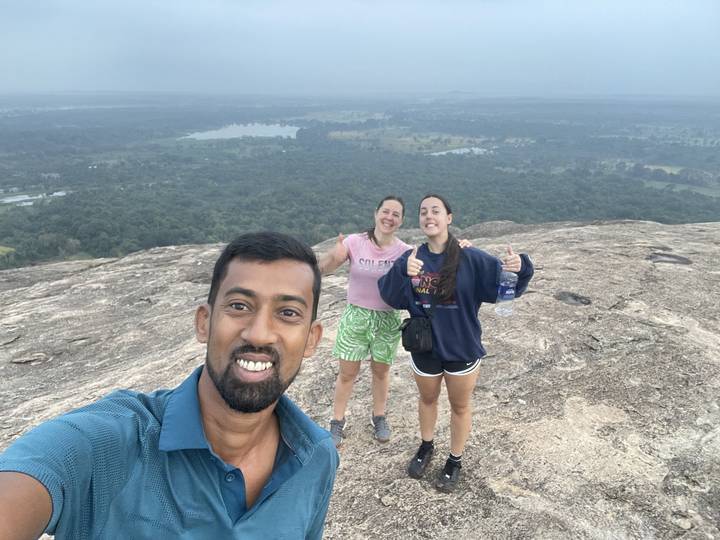 Des gens posés sur un affleurement rocheux avec des vues panoramiques.