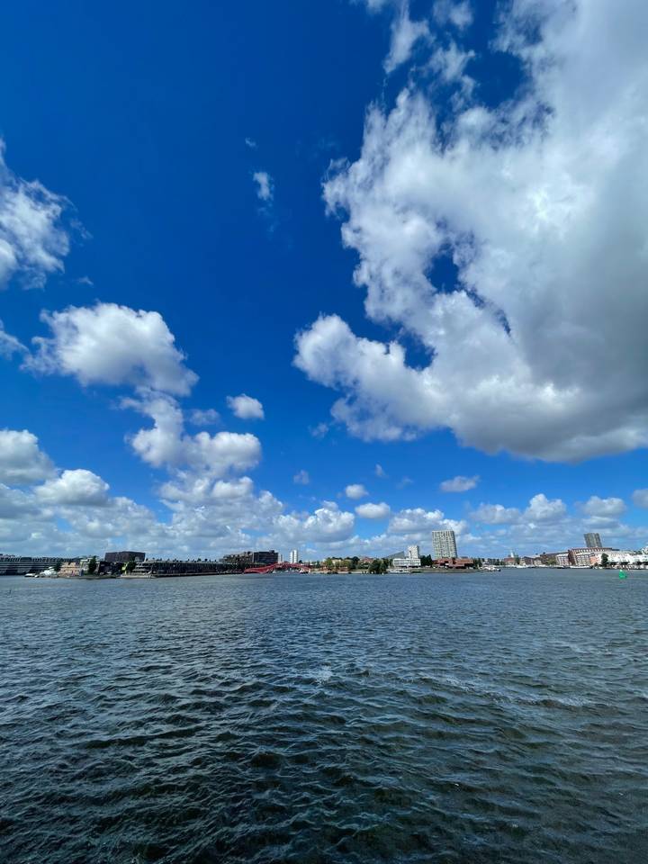 Vue sur le front de mer avec horizon urbain sous un ciel bleu.