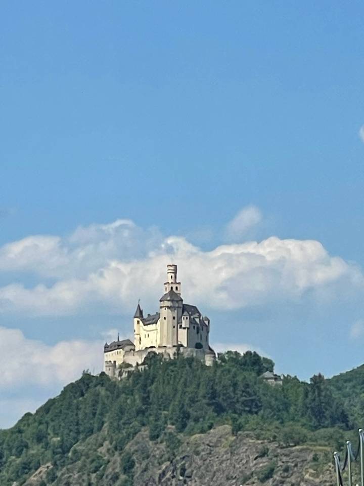 Château historique sur une colline avec un paysage verdoyant environnant.