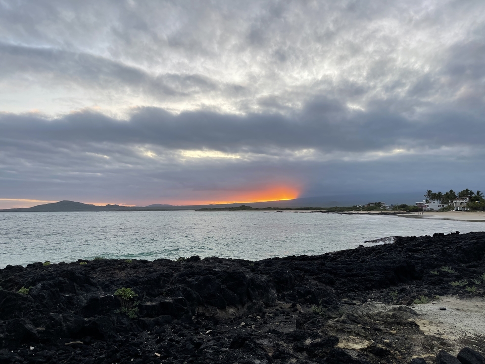 Un coucher de soleil sur l'océan avec des nuages.