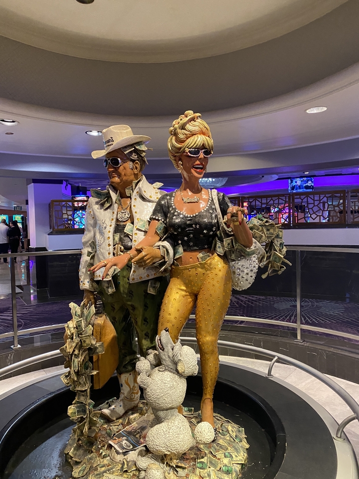 Deux statues avec des tenues voyantes à l'intérieur d'un casino.