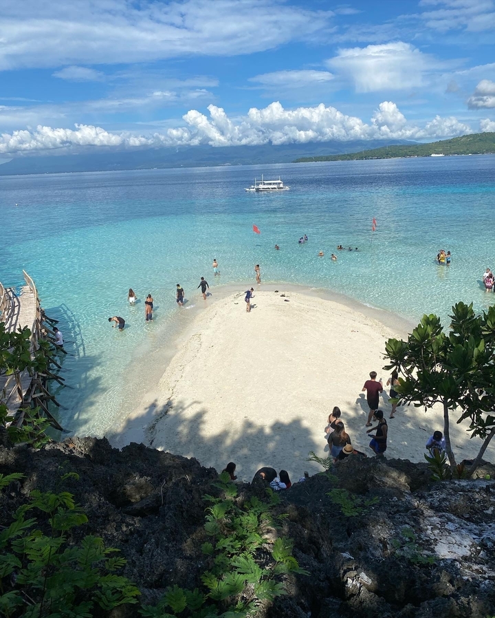 Des gens profitant de la plage avec une mer bleue claire.