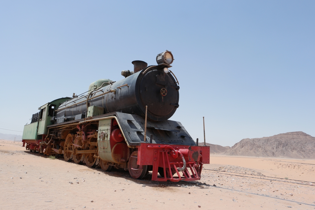 Ancienne locomotive à vapeur dans un décor désertique.
