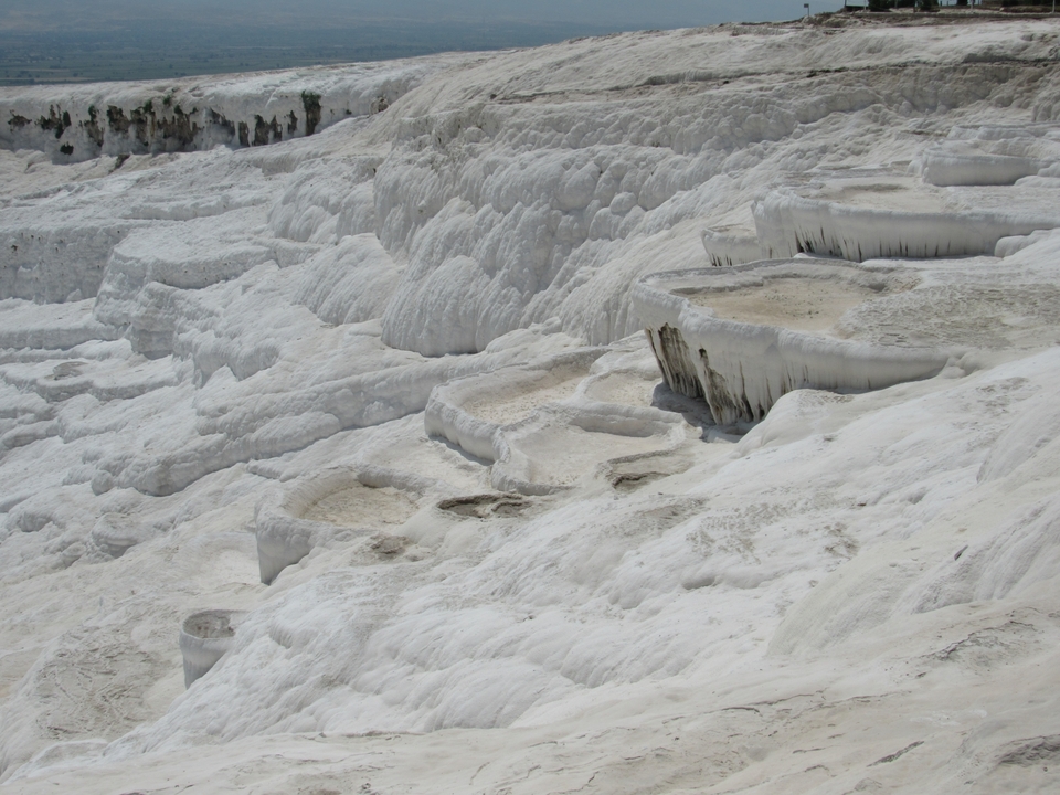 Terrasses de travertin blanc remplies d'eau.