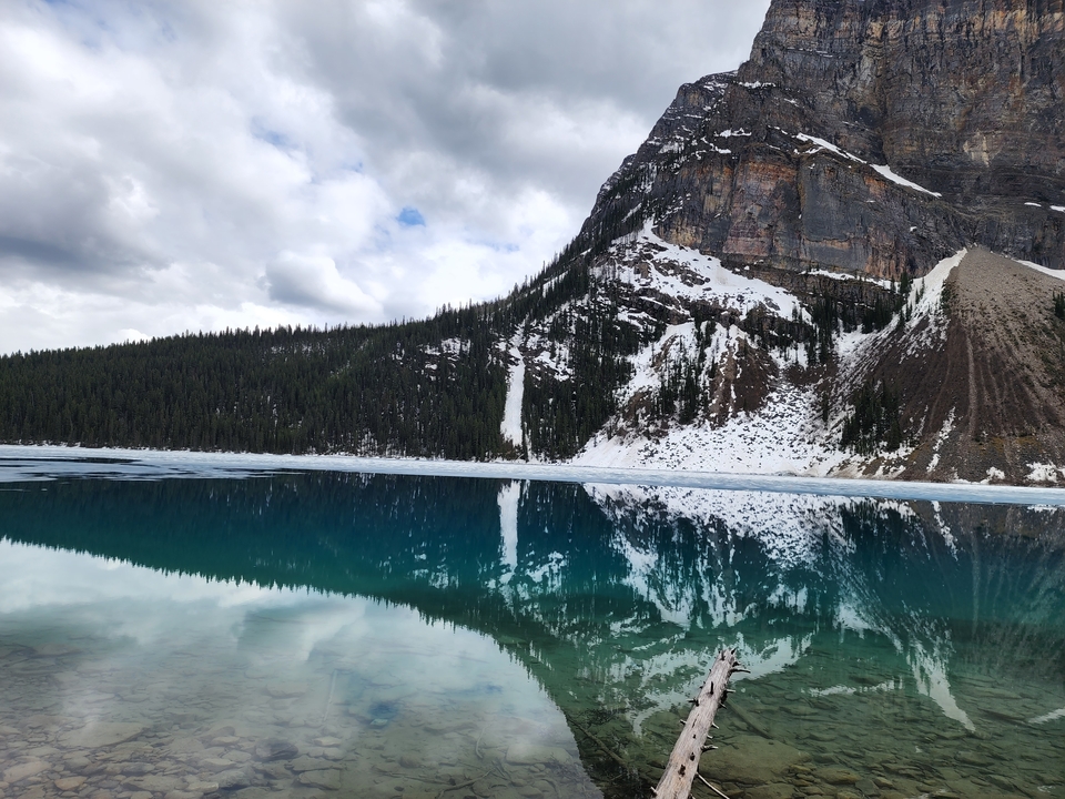 Reflets de montagnes enneigées sur un lac turquoise.