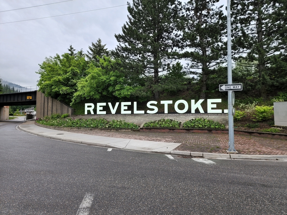 "Panneau de Revelstoke au bord d'une route avec de la verdure autour."