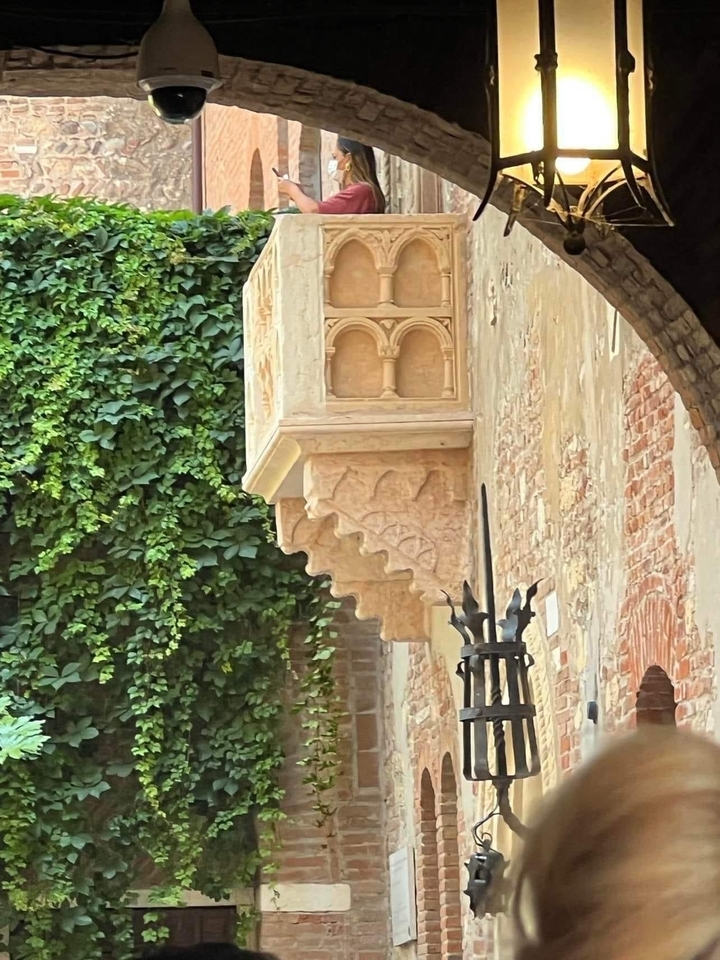 Balcon orné recouvert de verdure sur un bâtiment historique.