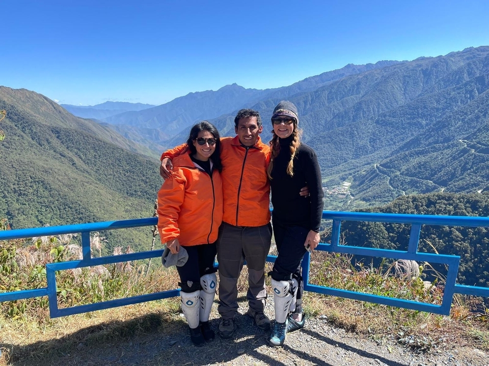 Groupe de personnes au sommet d'un point de vue avec des chaînes de montagnes au loin.