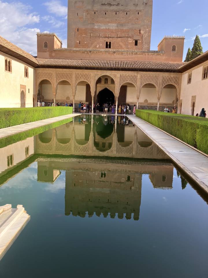 Reflets d'une structure architecturale dans l'eau.