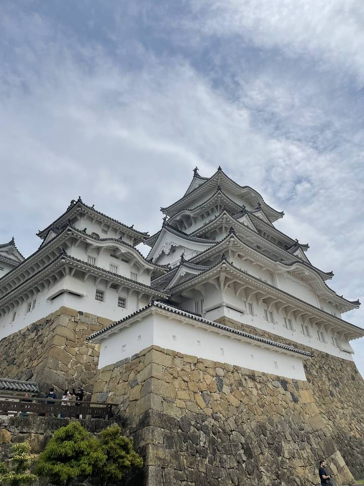 Le château de Himeji construit sur une colline sous un ciel bleu.