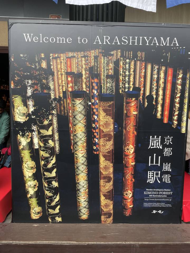 Piliers décoratifs à la gare d'Arashiyama avec panneau de bienvenue.