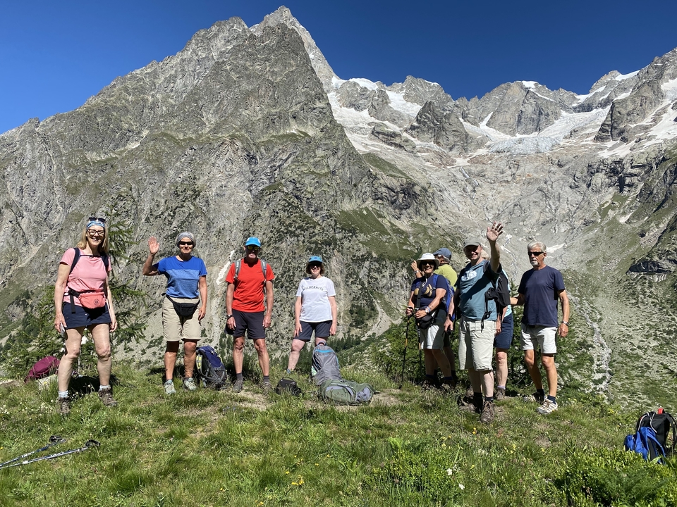 Groupe de randonneurs posant avec des montagnes en arrière-plan.