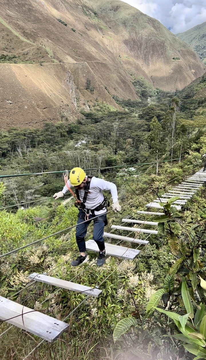 Personne utilisant un pont de corde dans une forêt.