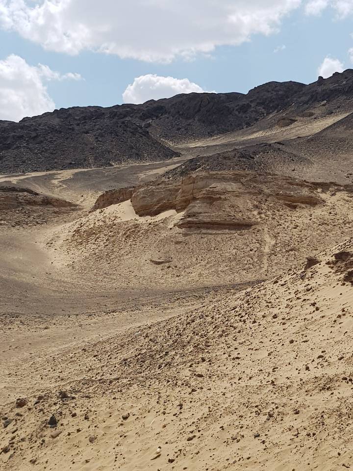 Paysage désertique avec formations rocheuses et sable.